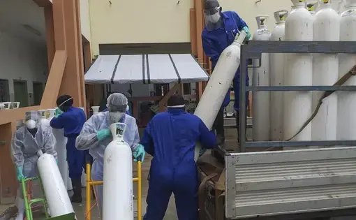 Medical workers offload cylinders of oxygen at the Donka public hospital where coronavirus patients are treated in Conakry, Guinea, on Wednesday, May 20, 2020. Before the coronavirus crisis, the hospital in the capital was going through 20 oxygen cylinders a day. By May, the hospital was at 40 a day and rising, according to Dr. Billy Sivahera of the aid group Alliance for International Medical Action. Oxygen is the the facility's fastest-growing expense, and the daily deliveries of cylinders are taking…